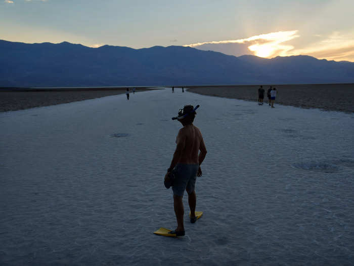 As the sun dipped below the valley, one tourist seemingly poked fun at the bone-dry landscape by putting on a pair of flippers and snorkel at the Badwater Basin in Death Valley, a salt flat lacking any signs of life other than its human visitors.