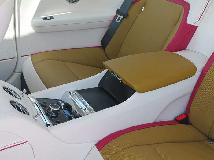 There are two seats in back, separated by a console with cupholders, air vents, and climate controls.