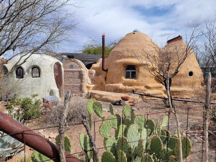 The process of building an adobe structure includes piling bundles of sandbags and earth on top of each other, with barbed wire between, and coating the outside with a cement mixture to lock it all in.