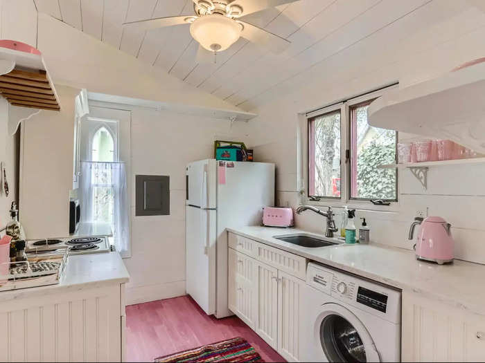 There are pops of pink everywhere in this little cottage, from kitchen appliances, to the floors, to the gingerbread-house-like trim around the windows.