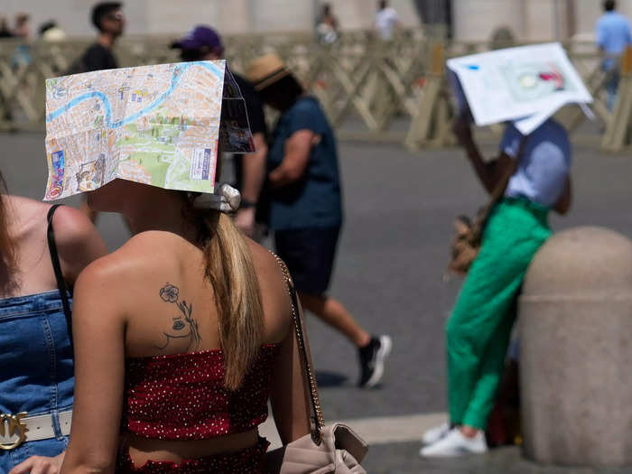 In Vatican City, some tourists were snapped using maps of Rome and newspapers to shelter from the sun rays.