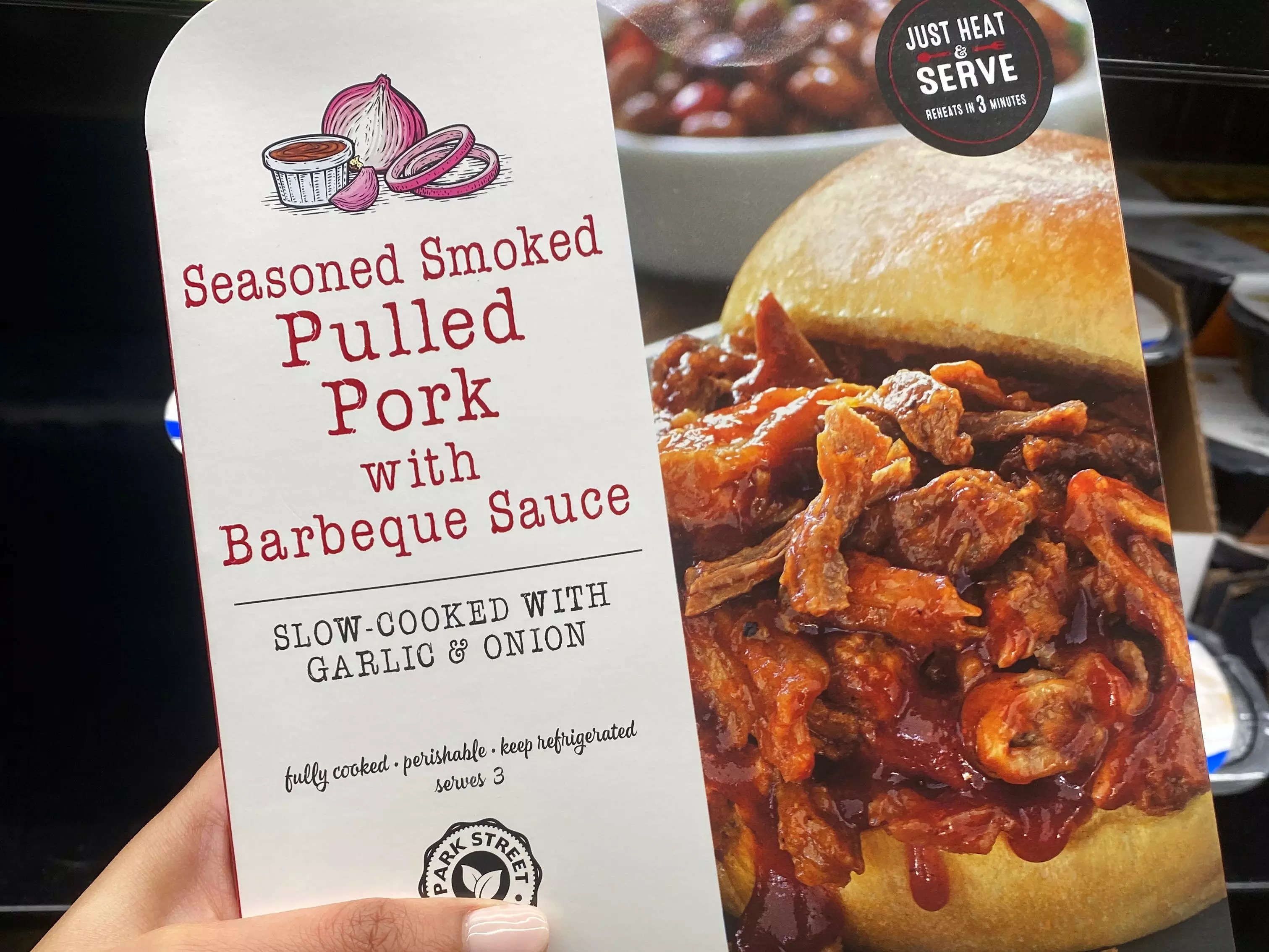 Hand holding pack of pulled pork at Aldi