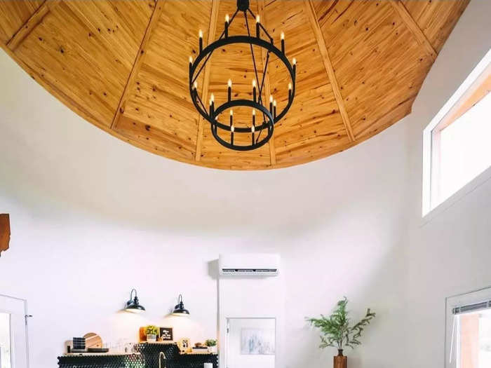 The living room is modern, with hardwood floors and a tiled accent wall in the kitchen.