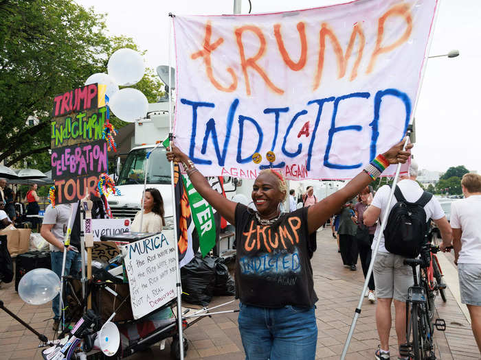 Anti-Trump protesters also made an appearance at the courthouse. A large white flag read, "Trump indicted again again."