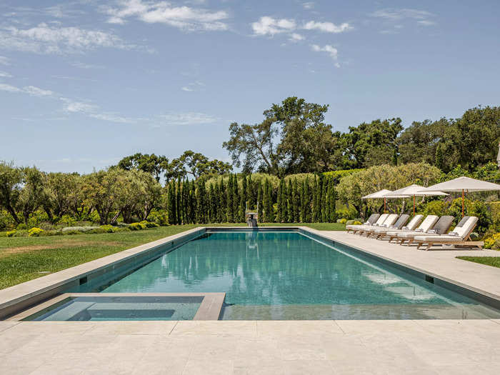 Guests can relax at the outdoor pool, which has several shaded sun loungers overlooking the lawn.