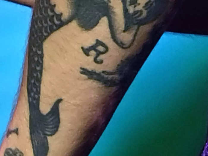 The "R" on his left arm is likely a nod to his stepdad, Robin Twist.