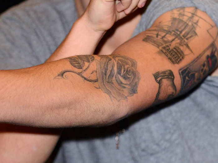 Styles has a large rose on his left arm.