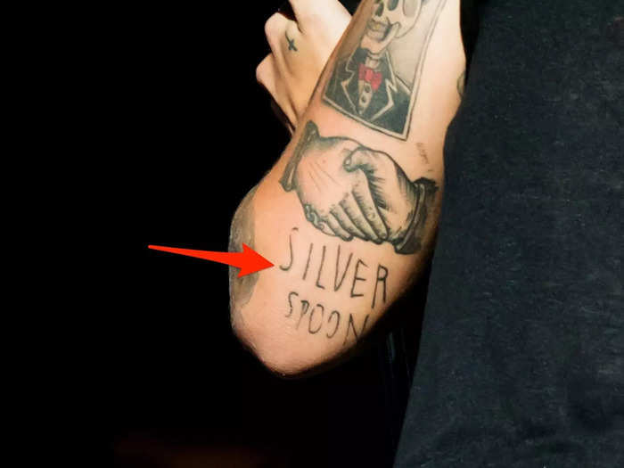 The phrase "silver spoon" can be seen on the back of his left arm.