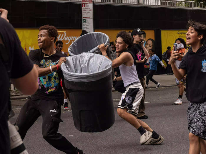 Some people threw objects like trash cans as the NYPD attempted to clear the crowds.