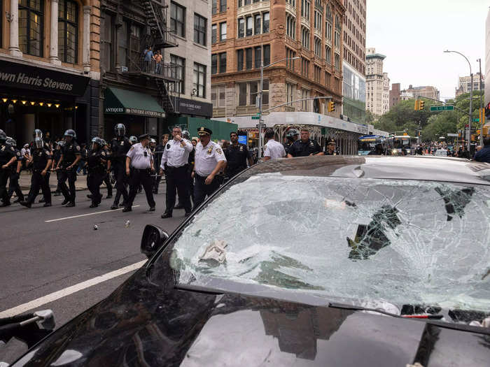 Residents stood on their fire escapes and looked out store windows to watch the NYPD clear the crowd.