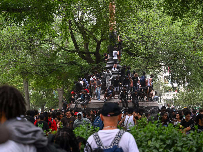 Others scaled a statue in Union Square Park, where throngs of people gathered before the NYPD cleared the crowds.