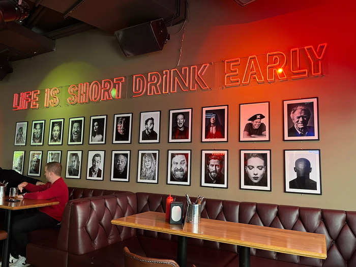 On another, a neon sign read "Life is short, drink early" above black-and-white portraits of American celebrities like Dolly Parton and Jake Gyllenhaal.