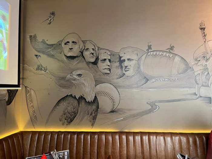 On one wall, a mural depicted a collage of Mount Rushmore, a bald eagle, a baseball, a football, and a hot dog.