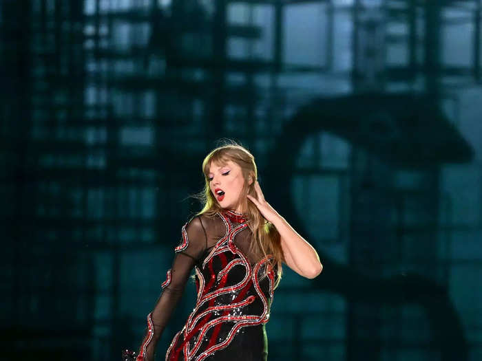 Her "Reputation"-themed outfit, for example, includes black boots and an asymmetrical catsuit decorated with a sparkling, red snake design.