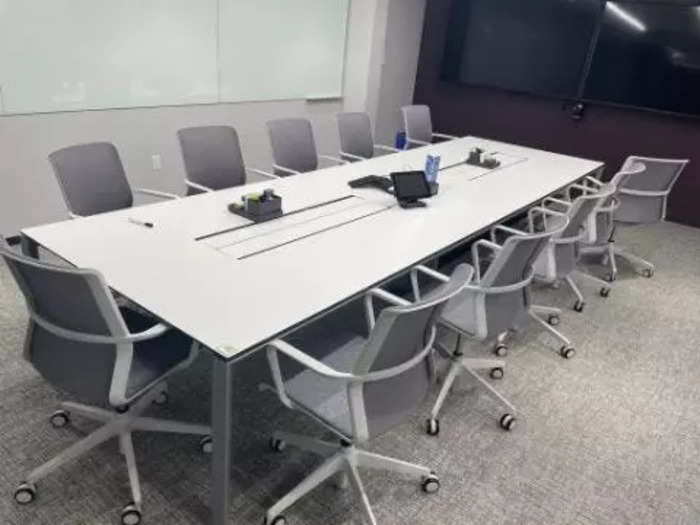 This white conference table with twelve gray and white swivel chairs is one of the many conference room sets available.