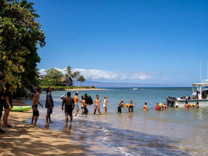 Dozens of residents in Kahana, just over 10 minutes north of Lahaina, stood in line to transport resources from a boat to the island.