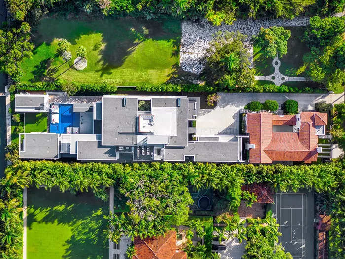 An aerial photo shows the two homes next to each other on the 0.92-acre plot — the guest house is on the right, with the terracotta roof.