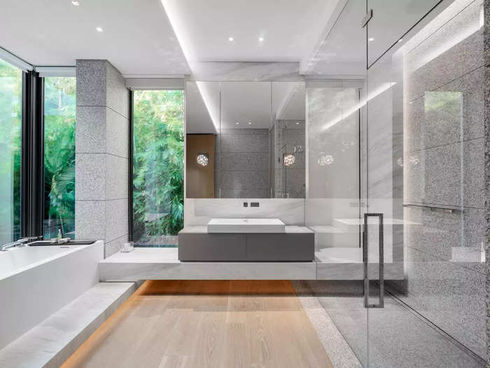 This bathroom features a walk-in shower, a tub, and more floor-to-ceiling windows to take in the stellar views.