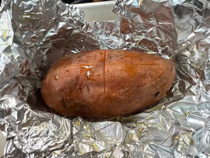 When the sweet potato is ready, carefully remove it from the foil and using a fork shimmy it over to a plate. Using the same fork, pull open the potato skin at the top, and add salt and pepper before topping with the fried halloumi.