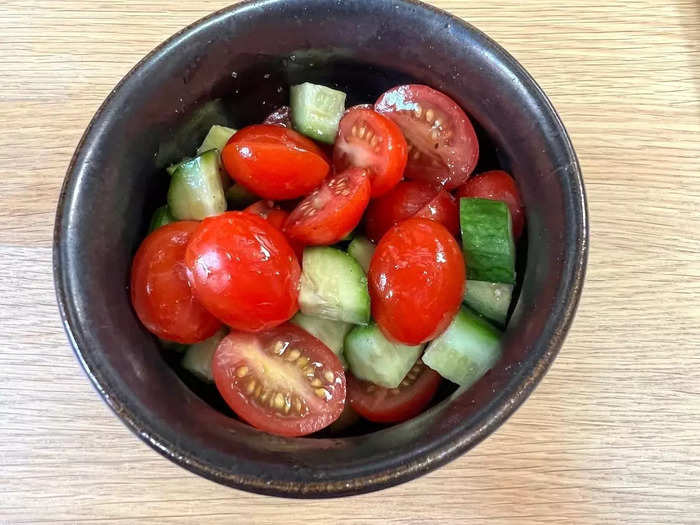 While your halloumi is cooking, make the salad. I like to keep it simple and just cut up some cucumbers and cherry tomatoes. Then, I add salt, pepper, olive oil, and balsamic vinegar to dress the salad.