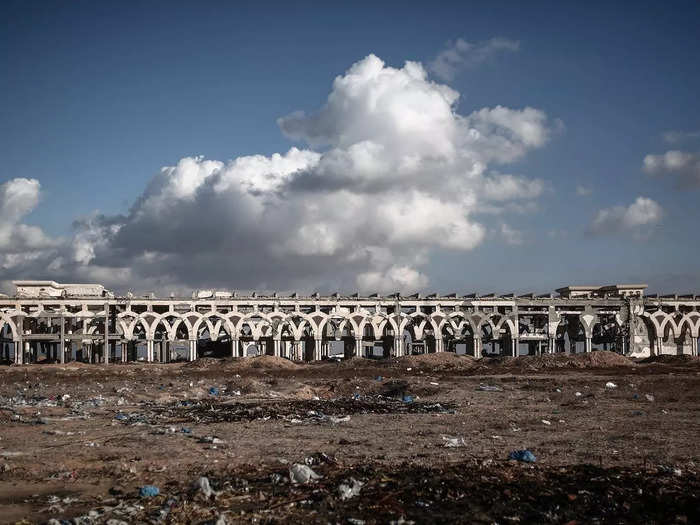 Remnants of a now-forgotten runway are littered with trash and debris.