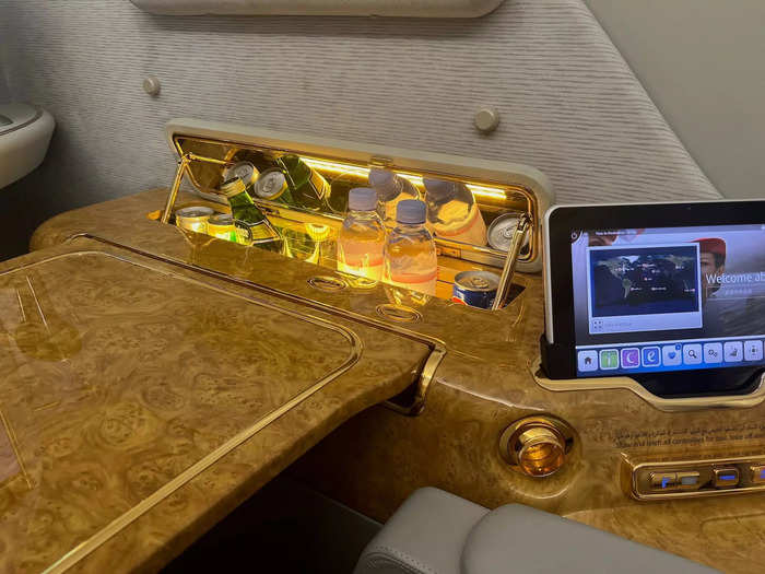 The television is controlled by a handheld tablet next to the seat, and travelers have access to their own personal mini bar to elevate the experience.