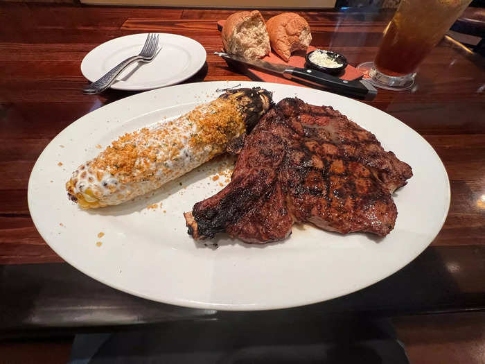 My medium-rare bone-in rib eye landed with a sheen of lemon butter and a side of corn on the cob. It smelled delicious.