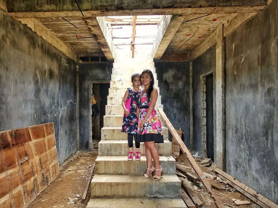 Two women standing in a half-built building.