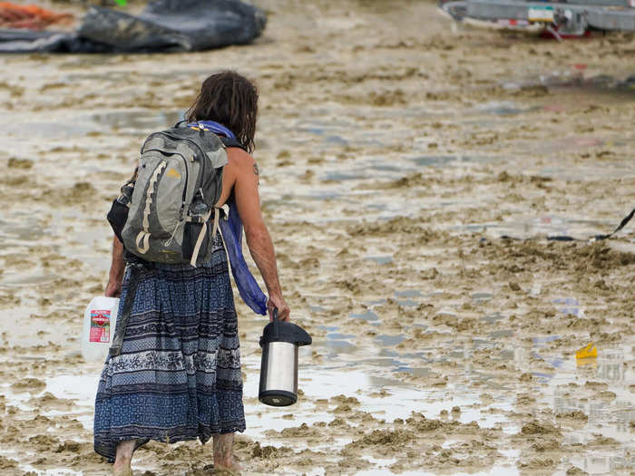 This woman carried a plastic water bottle and thermos as she trekked through the ankle-high mud.