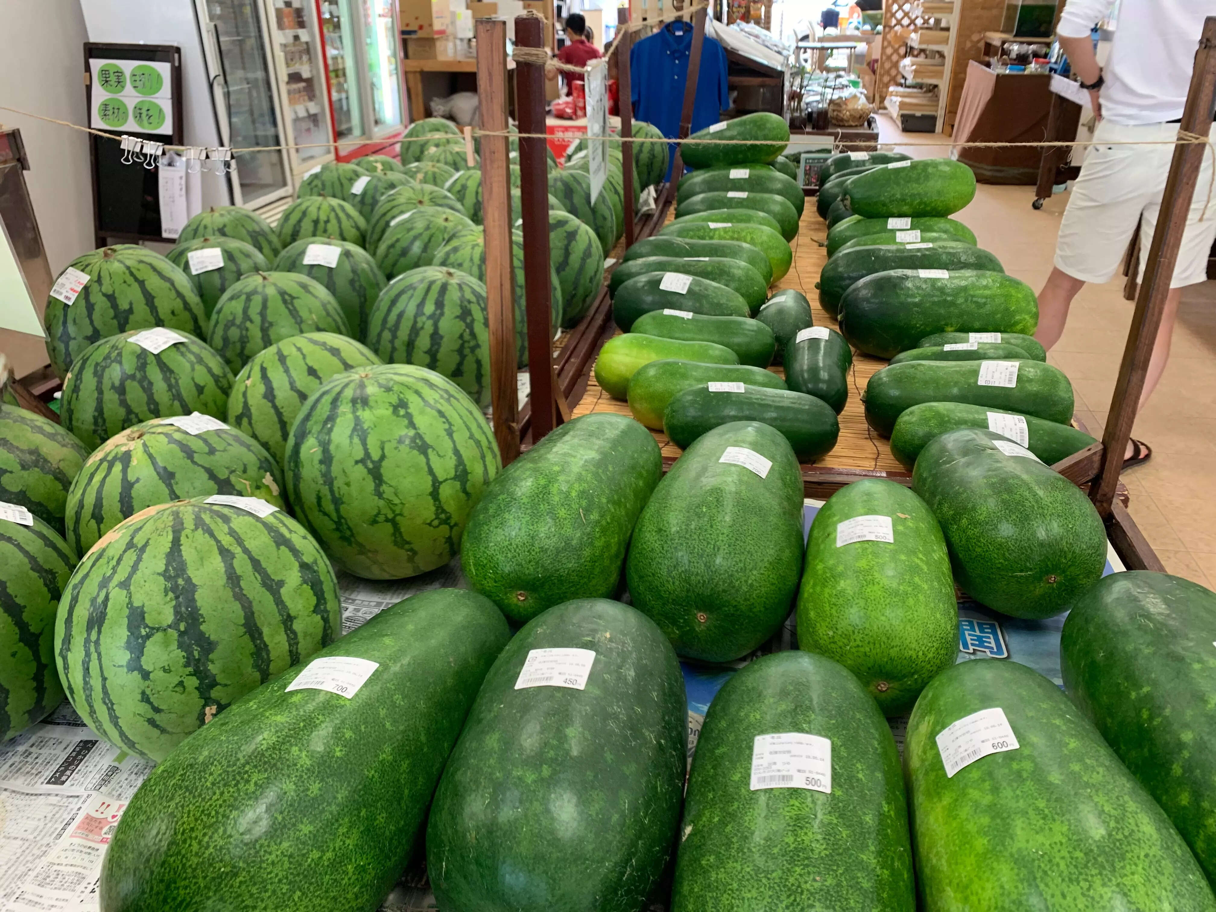 Watermelon and winter melon laid out at a market stall.