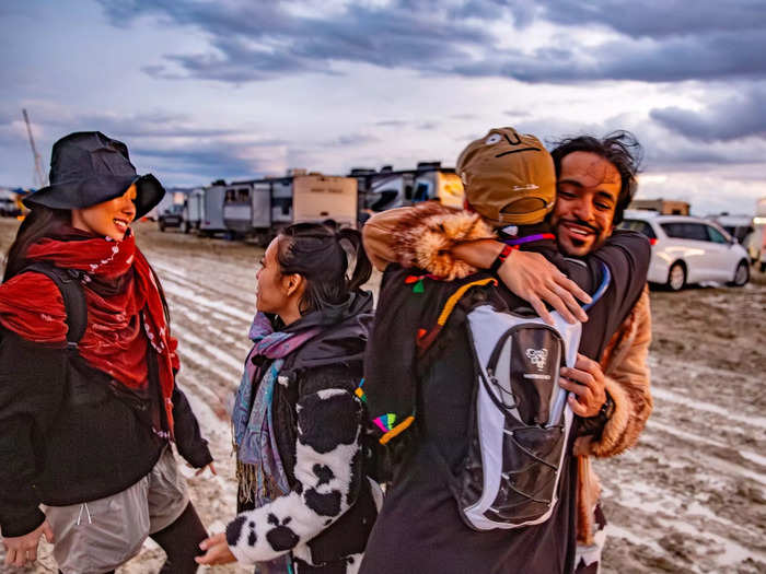 Burners greet each other on the mud-soaked street.