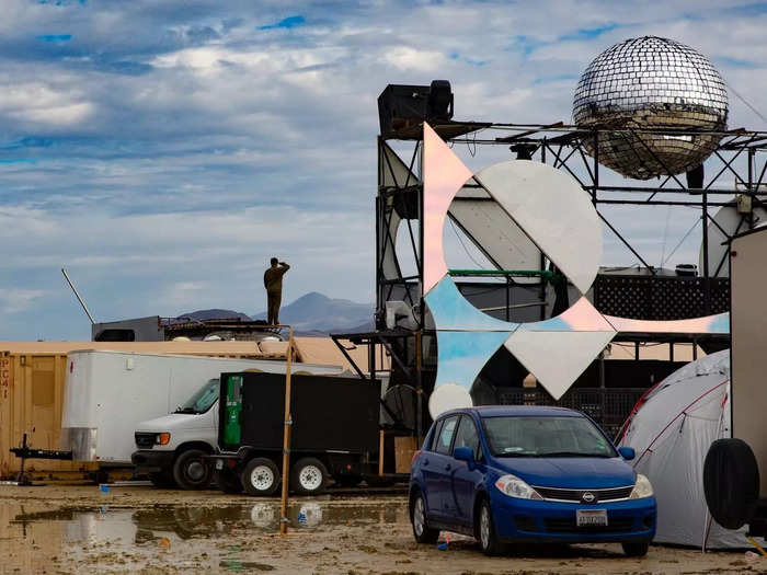 A burner takes in the view of the flooded playa near the Discow art car on Saturday morning after the first major storm