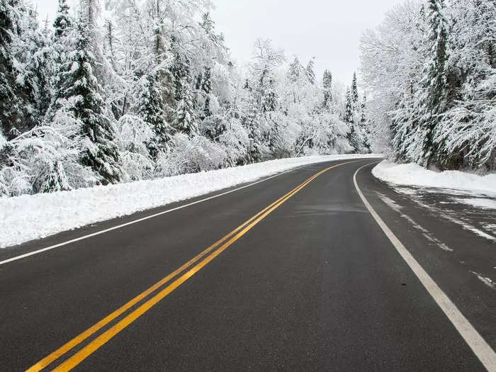 The winding mountain roads become lined with snowy trees when winter arrives.