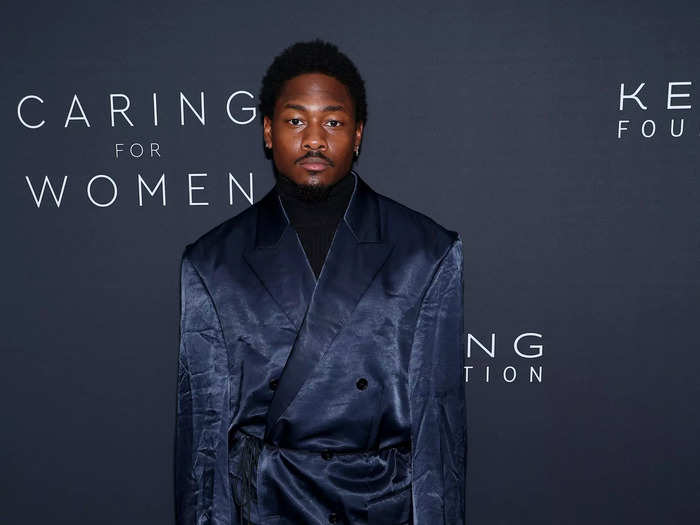 Stefon Diggs wore an oversized, navy suit that had a sheen to the fabric. The jacket belted at his waist.