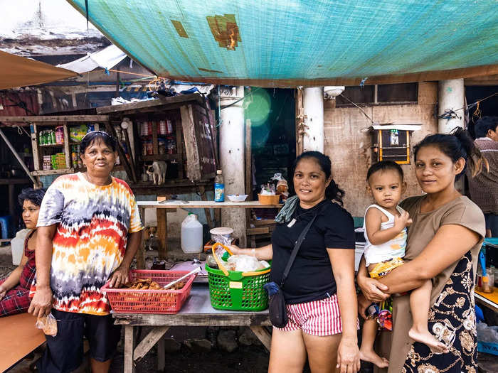 Neighbors Neriluz, Genelyn, and Merlia have lived in the cemetery for between 10 to 20 years. They sell popular Filipino street food from a stall in the cemetery.