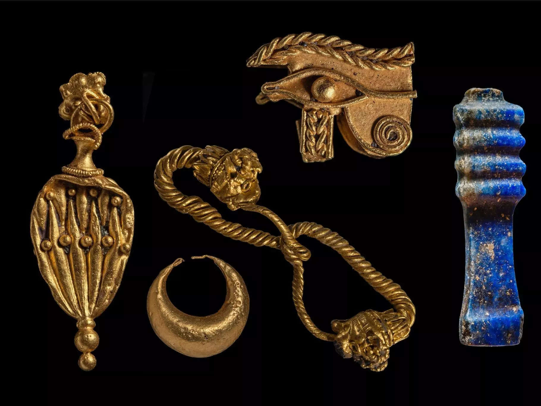 Gold jewelry and Egyptian symbols are shown here, next to a Lapis-Lazuli sculpture.