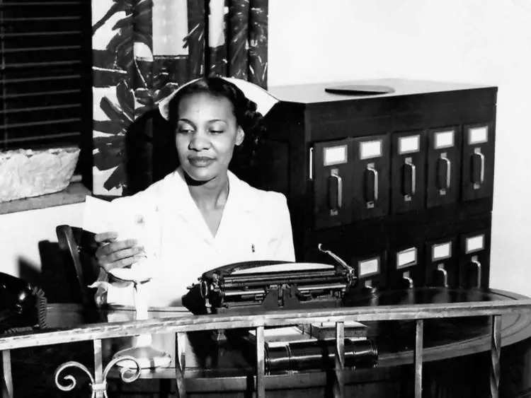 A black and white photograph of Ruby Cole working as a nurse.