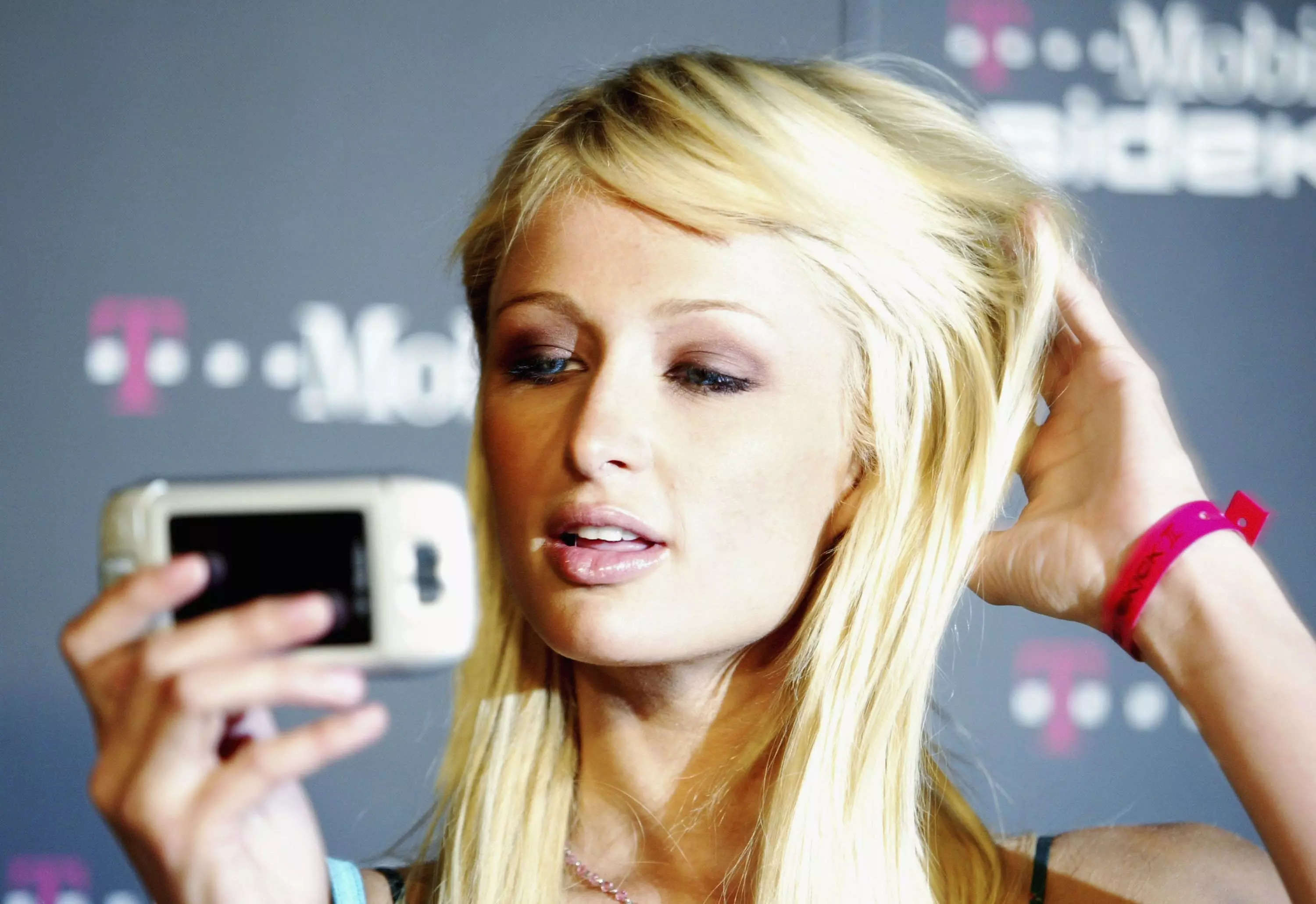 Paris Hilton holding a mobile phone.