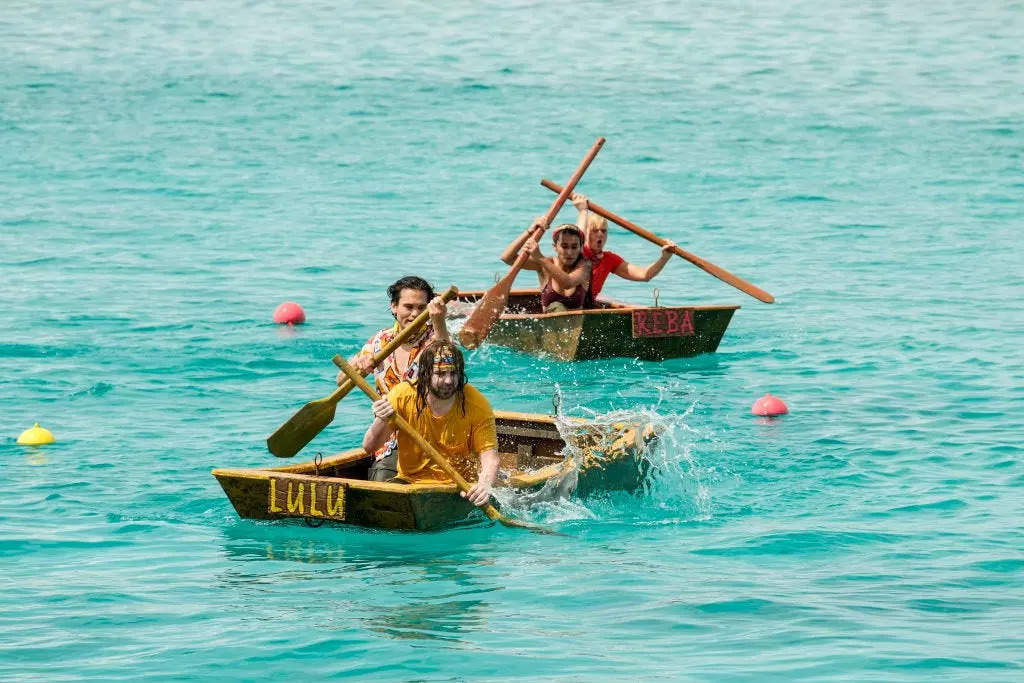Survivor 45 players rowing on small boats during a competition