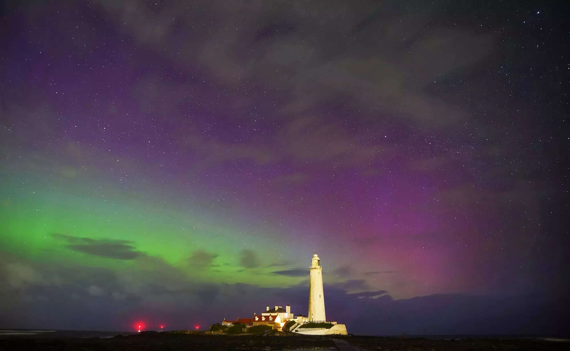 Auroras seen above a lighthouse.