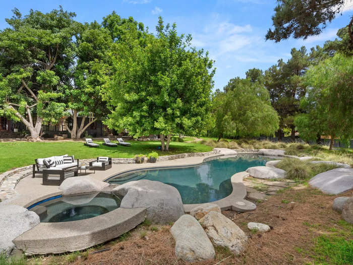 The "large free-form pool" surrounded by trees sits right outside the 1940s-style ranch home.