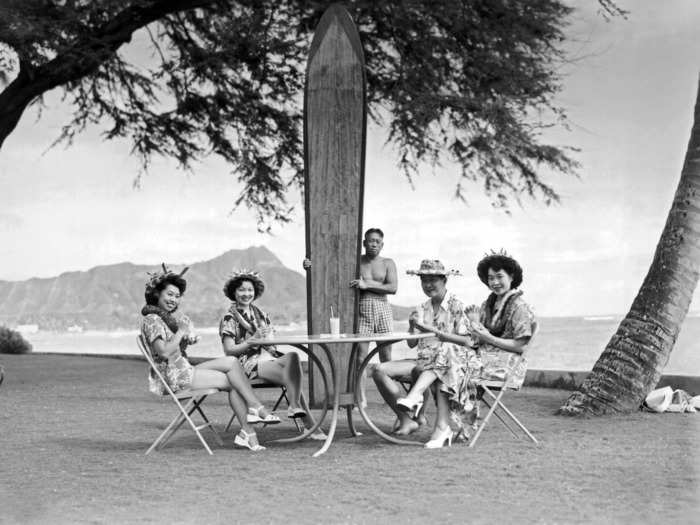 1930: Four Japanese tourists pose at the Halekulani Hotel on Waikiki Beach. Tourism started to flourish in Hawaii after Waikiki