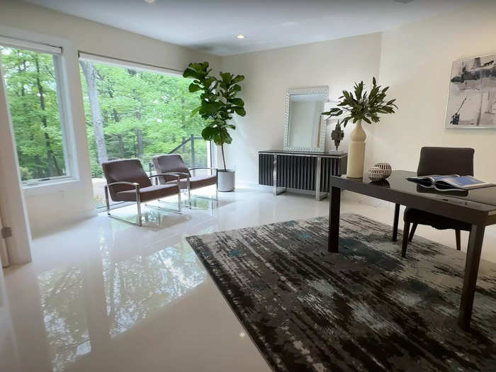 The home office, which has built-in shelving and full bathroom attached, has enough space for a desk, a sitting area, and more.