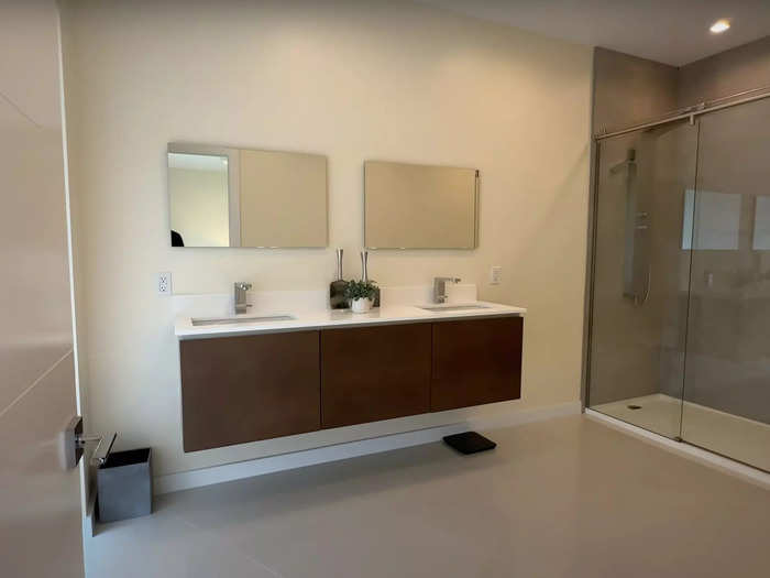 The en-suite bathroom features a double-vanity sink and a sizable shower.