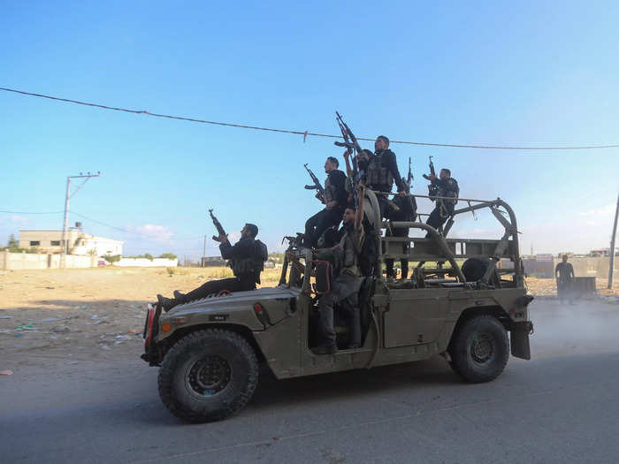 Palestinian militants ride an Israeli military vehicle that was seized by gunmen who infiltrated areas of southern Israel, in the northern Gaza Strip.