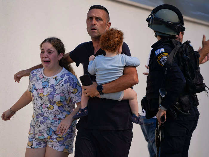 5. A family is evacuated by Israeli police from a site hit by a rocket.