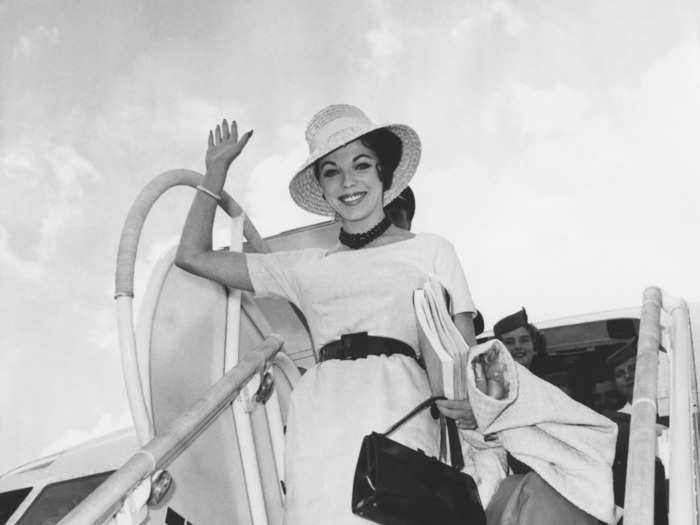 Joan Collins waved at the cameras as she arrived at Ciampino Airport in Rome in 1960 to star in the film "Esther and the King."