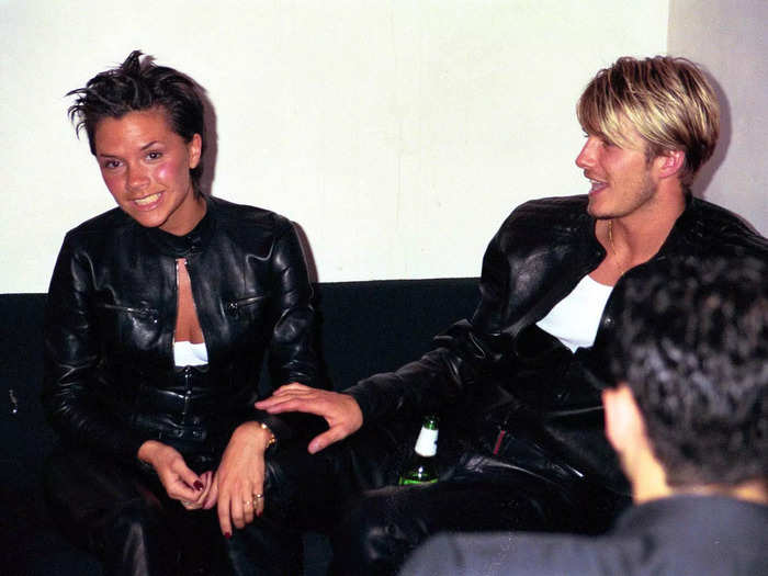 Victoria Beckham cracked a rare smile as David Beckham placed a hand on her arm in a photo snapped at a Versace party in 1999.