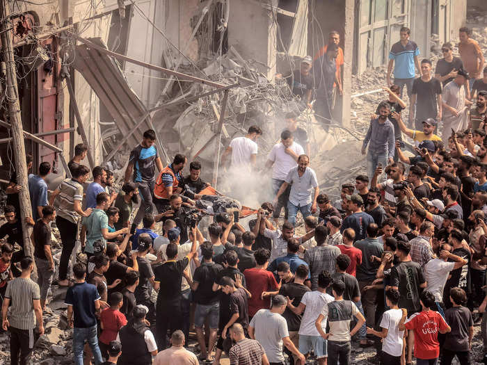 Following the attack on the Sousi mosque, Palestinians worked to evacuate a body from the destruction.