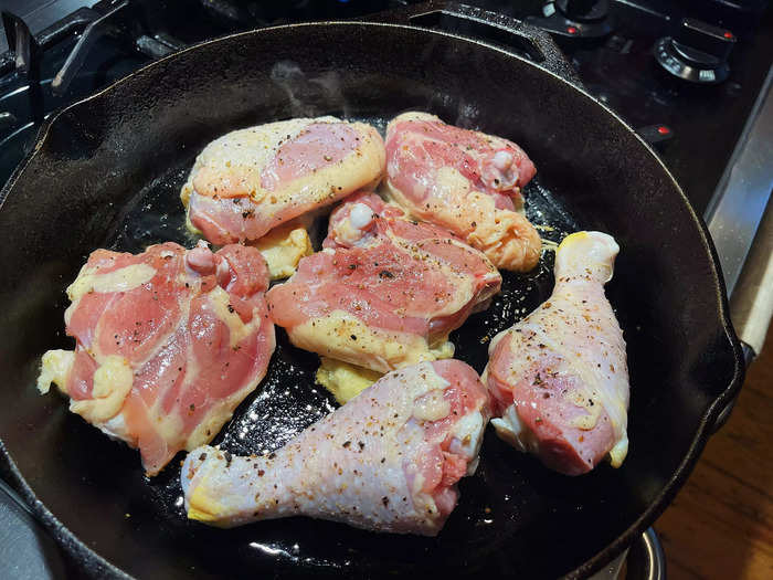 I then heated up a few tablespoons of oil in a 12-inch cast-iron pan, and I added the chicken skin-side down.